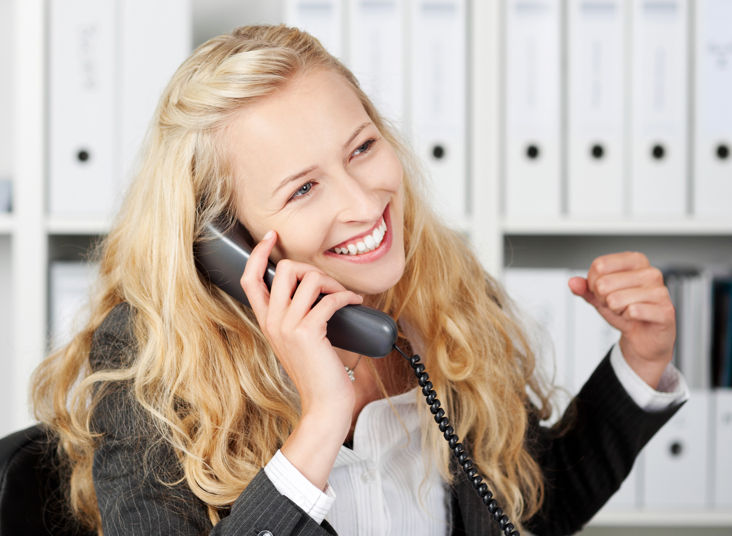 Young woman happily talking on the phone